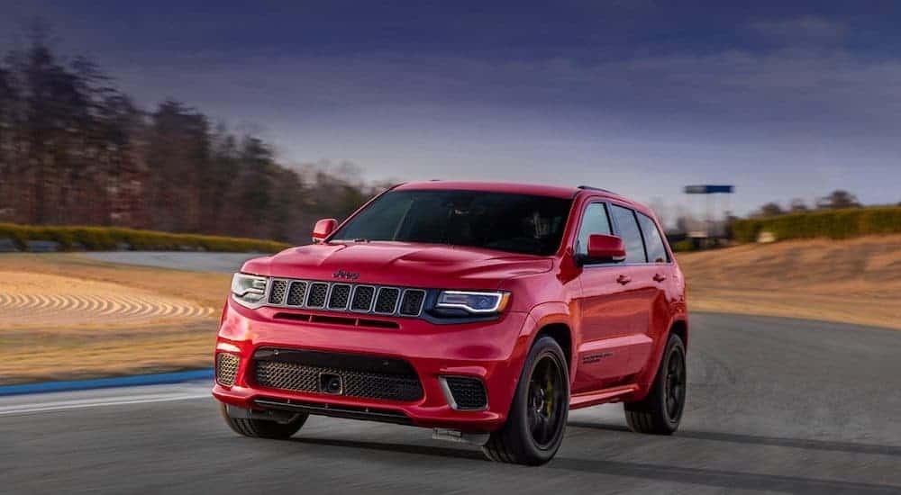 A red 2020 Jeep Grand Cherokee Trackhawk is cruising around a racetrack.