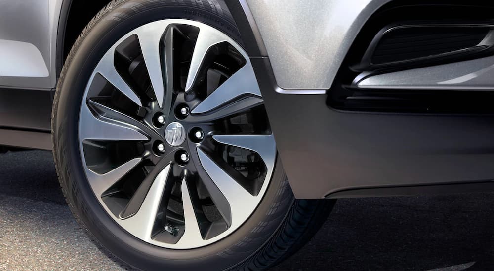 A close up is shown of the wheel on a silver 2021 Buick Encore.