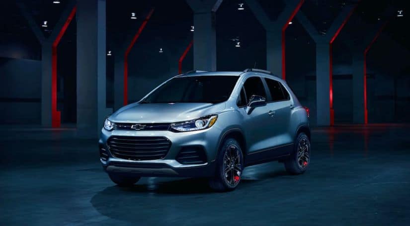 A silver 2021 Chevrolet Trax is sitting in the middle of a futuristic room with red accents.