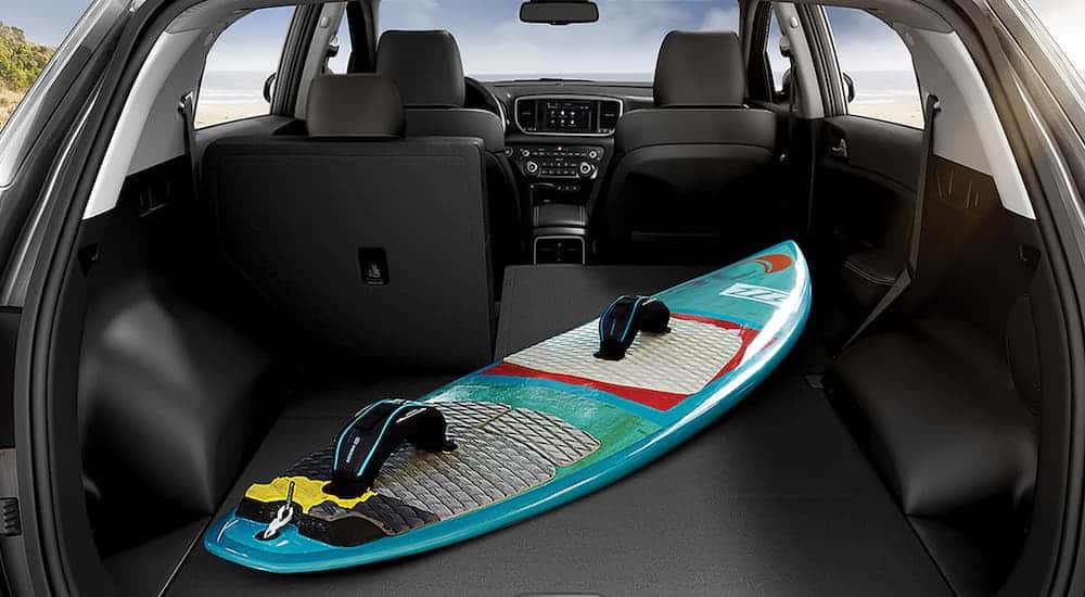 A surfboard in the rear cargo area is shown on the 2021 Kia Sportage.