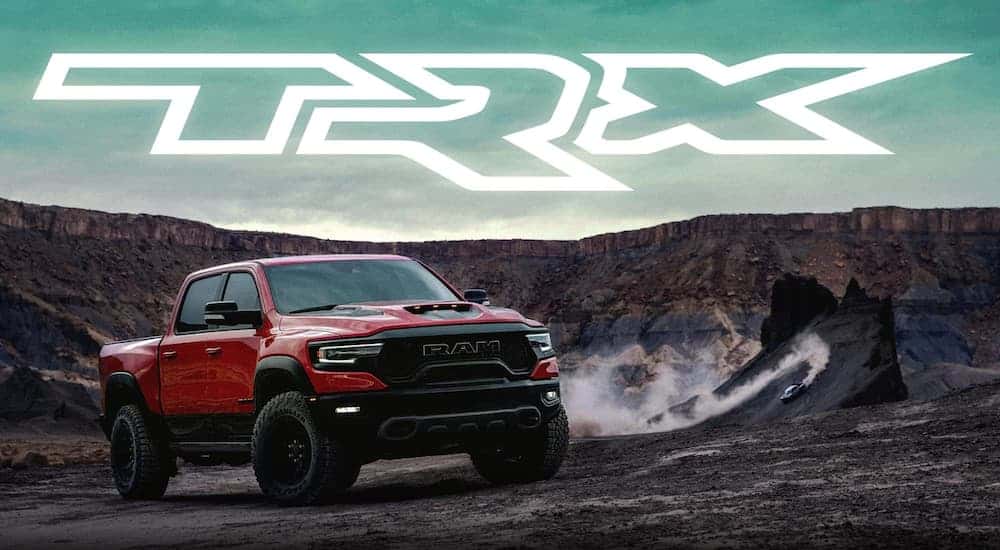 A red 2021 Ram 1500 TRX is parked with a large white TRX logo above it.