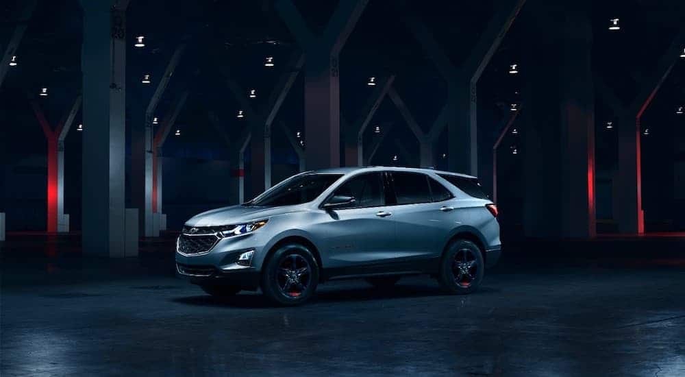 A silver 2017 used Chevy Equinox Redline is parked in a modern room with red and white accent lighting.
