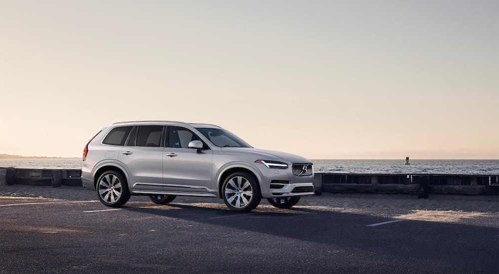 A silver 2021 Volvo XC90 is parked in front of a beach at dusk as part of the 2021 Buick Enclave vs 2021 Volvo XC90 comparison.