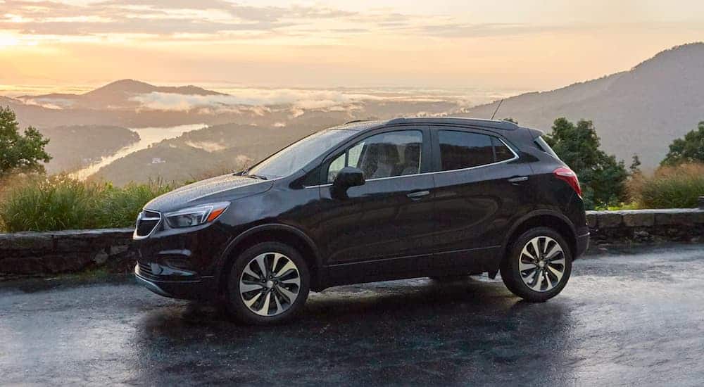 A black 2021 Buick Encore is parked at a mountain overlook at sunset.