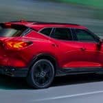 A red 2021 Chevy Blazer is shown in profile driving down the street.