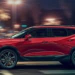 A red 2021 Chevy Blazer is shown from the side on a city street at night.