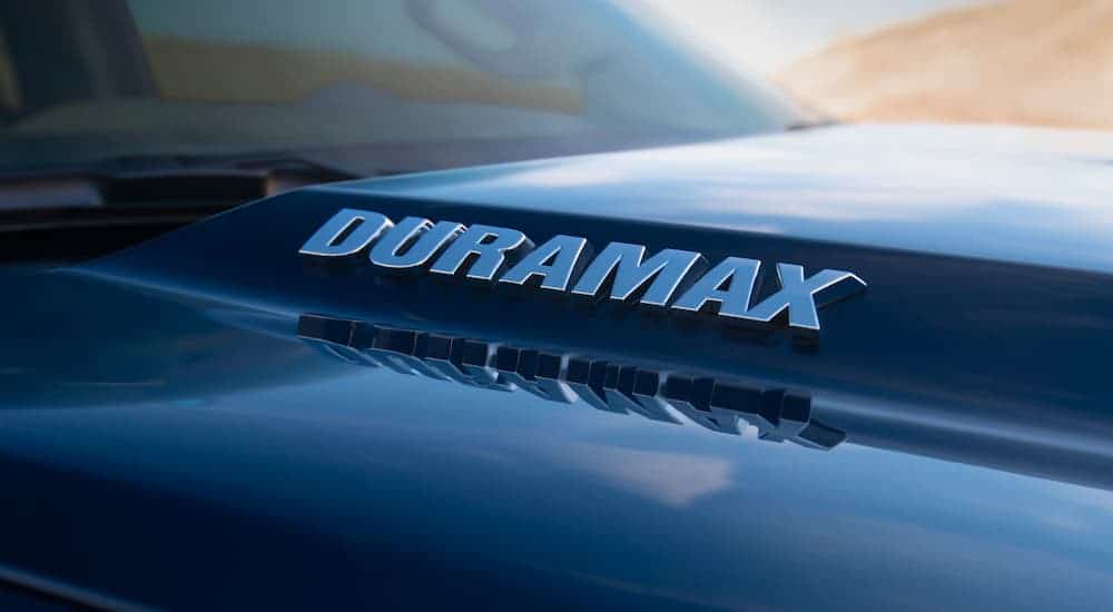 A close up is shown of the Duramax emblem on a black 2021 Chevy Silverado 1500.