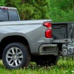 A silver 2021 Chevy Silverado 1500 is shown from the side with its Multi-Flex Tailgate open.