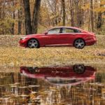 A red 2021 Honda Accord is shown from the side between two trees with a pond in the foreground.