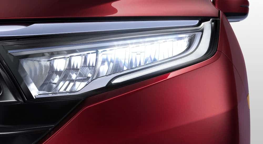 A close up is shown of the driver side LED headlight on a red 2021 Honda Odyssey Elite.