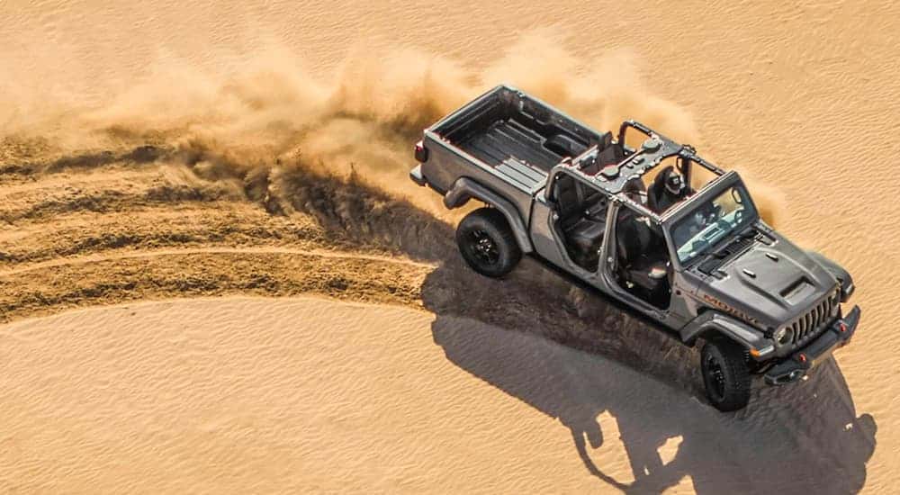 A grey 2021 Jeep Gladiator Mojave is shown from a high angle speeding through the desert.