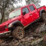 A red 2021 Jeep Gladiator Rubicon is driving down a rocky hill.