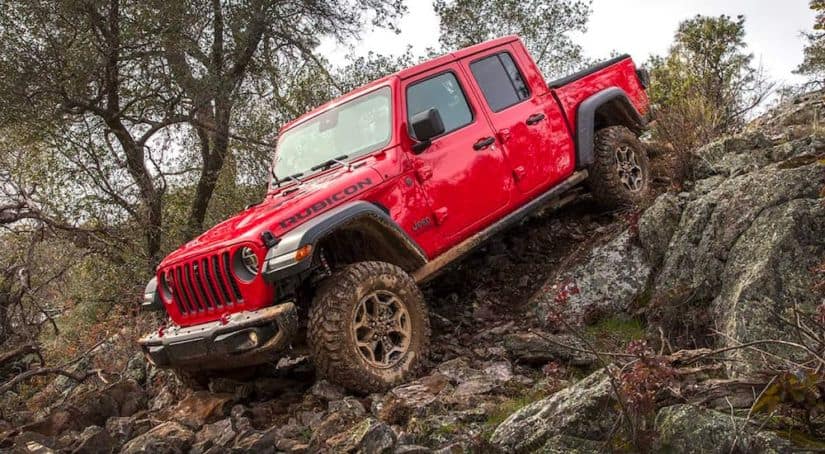A red 2021 Jeep Gladiator Rubicon is driving down a rocky hill.