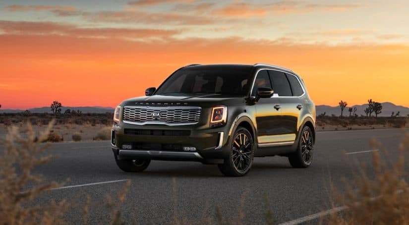 A black 2021 Kia Telluride is parked with a sunset in the background after winning the 2021 Kia Telluride vs Mazda CX-9 comparison.