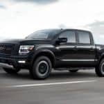 A black 2021 Nissan Titan is driving on a highway.