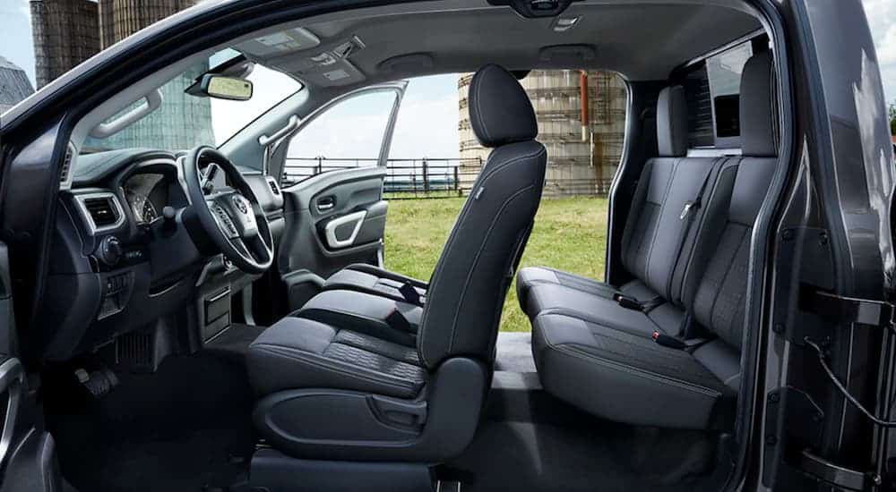 The grey interior of a 2021 Nissan Titan is shown from the side with all the doors open.