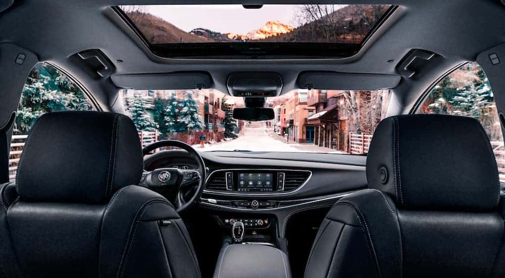 The black interior is shown from the back seat on a 2020 Buick Enclave.