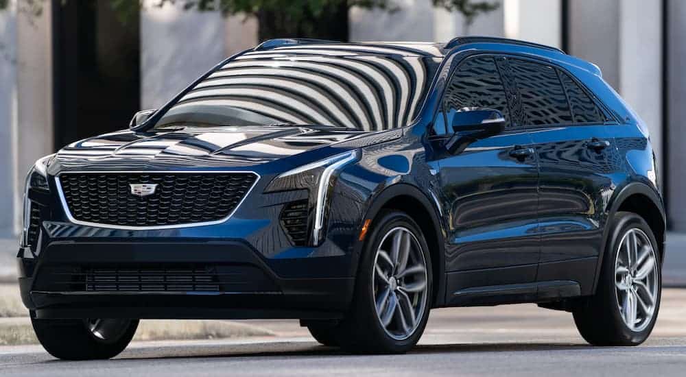 A black 2021 Cadillac XT4 is parked angled left with light reflecting off the windshield.
