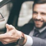 A woman is handing a man a set of keys after a car purchase at Chevy dealer in Norfolk.