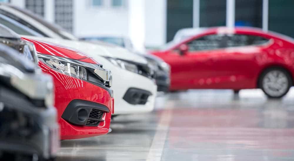A row of cars is shown at a car dealership.