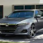 A silver 2021 Honda Accord is parked in front of a garage.