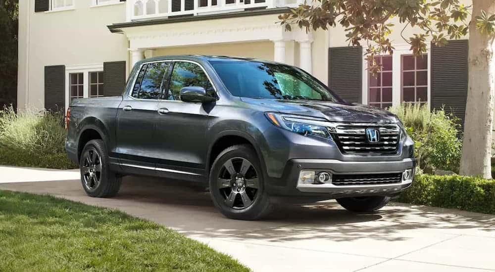 A dark grey 2021 Honda Ridgeline is parked in a driveway after leaving a greater Atlanta Honda dealer.