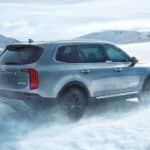 A 2020 Kia Telluride is driving through the snow.