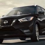 A black 2020 Nissan Kicks is driving away from the city.