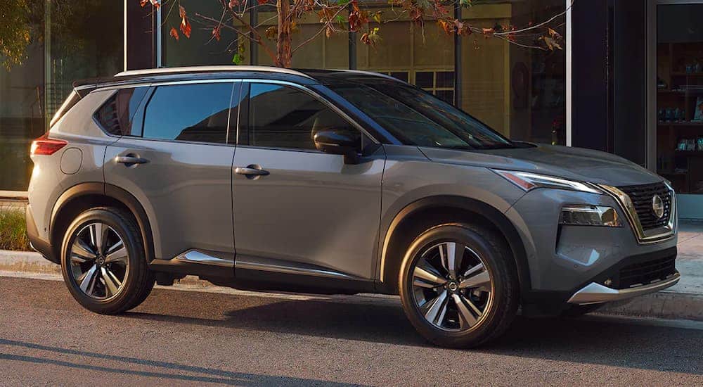 A grey 2020 Nissan Rogue is parked in the city shown in profile.