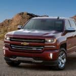 A red 2017 used Chevy Silverado 1500 Z71 is parked in the desert with hills in the background.