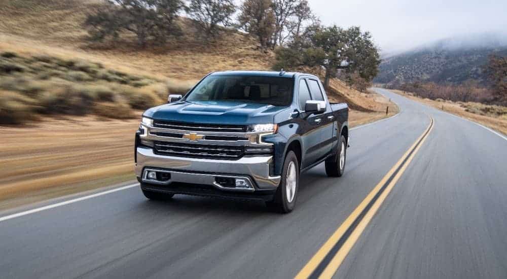 A blue 2019 Chevy Silverado 1500 diesel is driving on a highway.