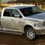 A popular used diesel truck in Colorado Springs, a silver 2014 Ram 1500 EcoDiesel is parked on a farm.