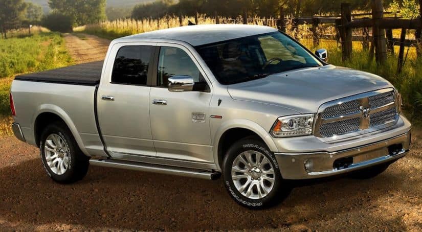 A popular used diesel truck in Colorado Springs, a silver 2014 Ram 1500 EcoDiesel is parked on a farm.