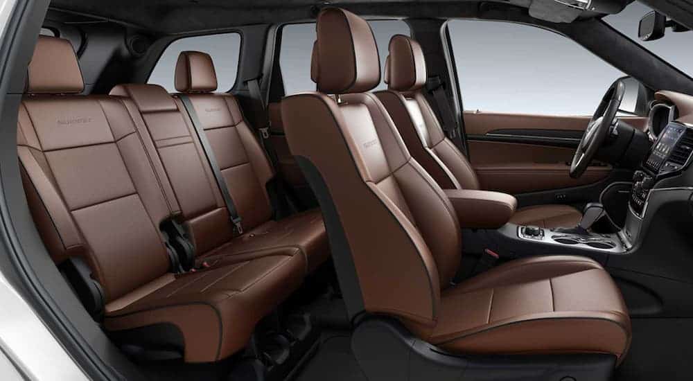 The brown interior of a 2020 Used Jeep Grand Cherokee Summit is shown from the side.