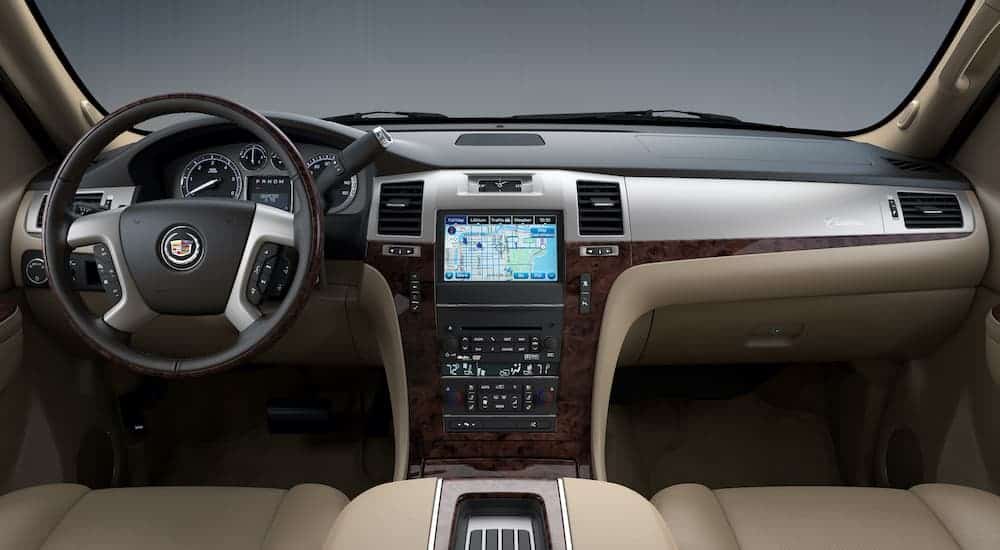 The interior and infotainment system is shown from the back seat on a 2014 Cadillac Escalade.