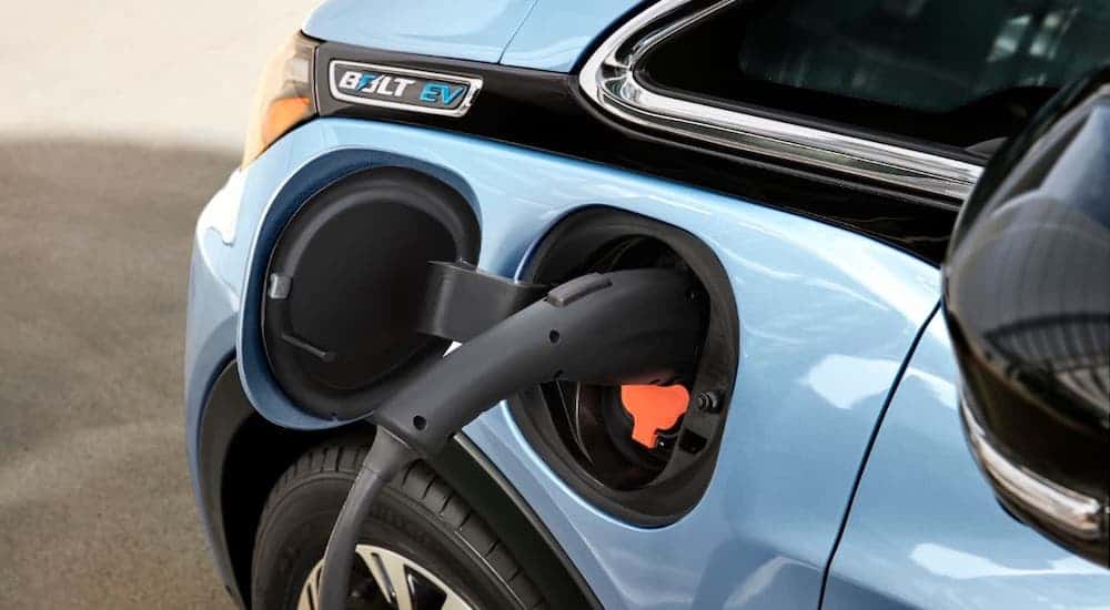 A closeup shows the charger on a light blue 2021 Chevy Bolt EV.