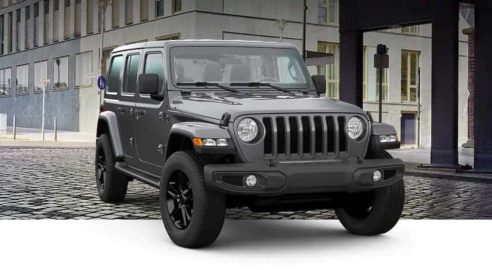 A gray 2021 Jeep Wrangler Unlimited High Altitude is angled right on a city street.