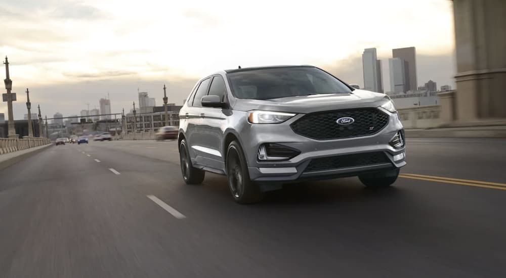 A silver 2022 Ford Edge is shown from the front driving on an open road.
