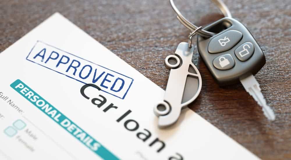 A bad credit car loan is stamped with 'Approved' next to car keys.