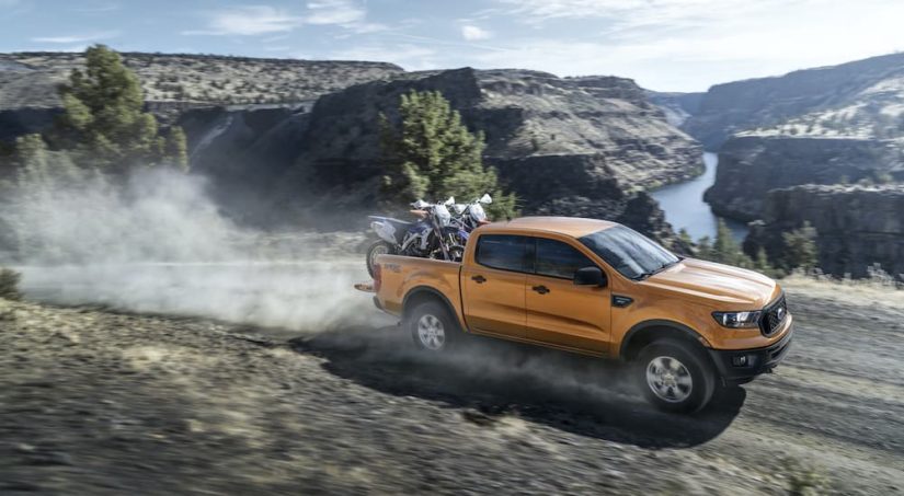 A yellow 2019 Ford Ranger is shown from the side driving on an open road after leaving a CPO Ford dealer.