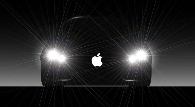 A silhouette of a car with it's headlights on has the apple logo over it.