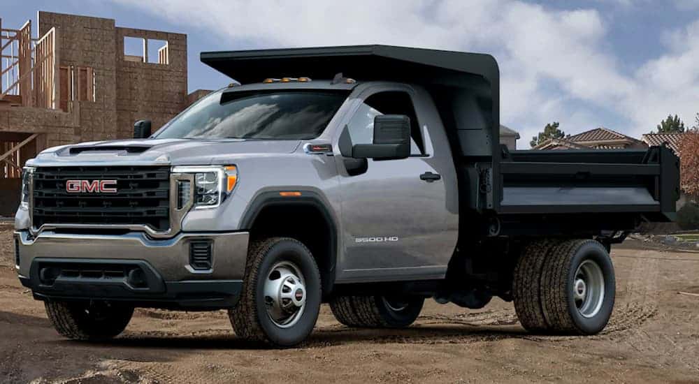 A grey 2020 GMC 3500 HD Chassis Cab is parked at a construction site.