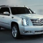 A silver 2014 Cadillac Escalade is driving in a tunnel.