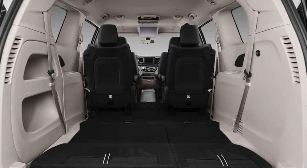 The black and grey interior is shown on a 2021 Chrysler Voyager from behind.
