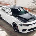 A white and black 2021 Dodge Charger SRT Hellcat Redeye Widebody is shown from a high angle parked in an empty garage.