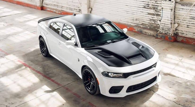 A white and black 2021 Dodge Charger SRT Hellcat Redeye Widebody is shown from a high angle parked in an empty garage.