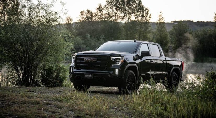 A black 2021 GMC Sierra 1500 Elevation is parked in front of a pond.