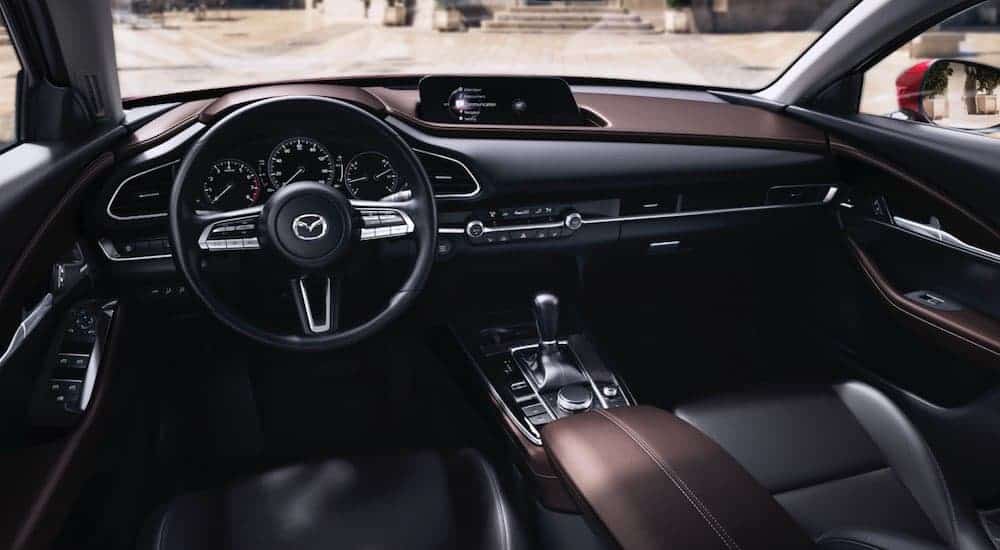 The dark brown and black, front seats and dash, are shown on a 2021 Mazda CX-30.