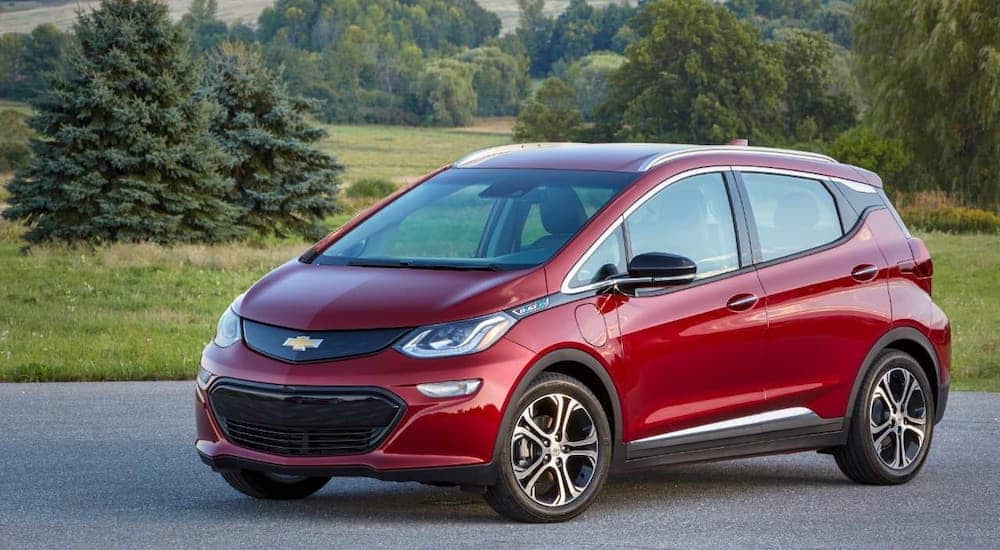 A red 2021 Chevy Bolt EV is parked in front of a valley.