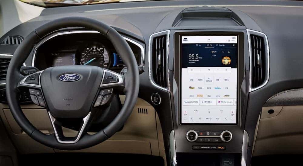 The steering wheel and large infotainment screen are shown in a 2021 Ford Edge at a Ford dealer.